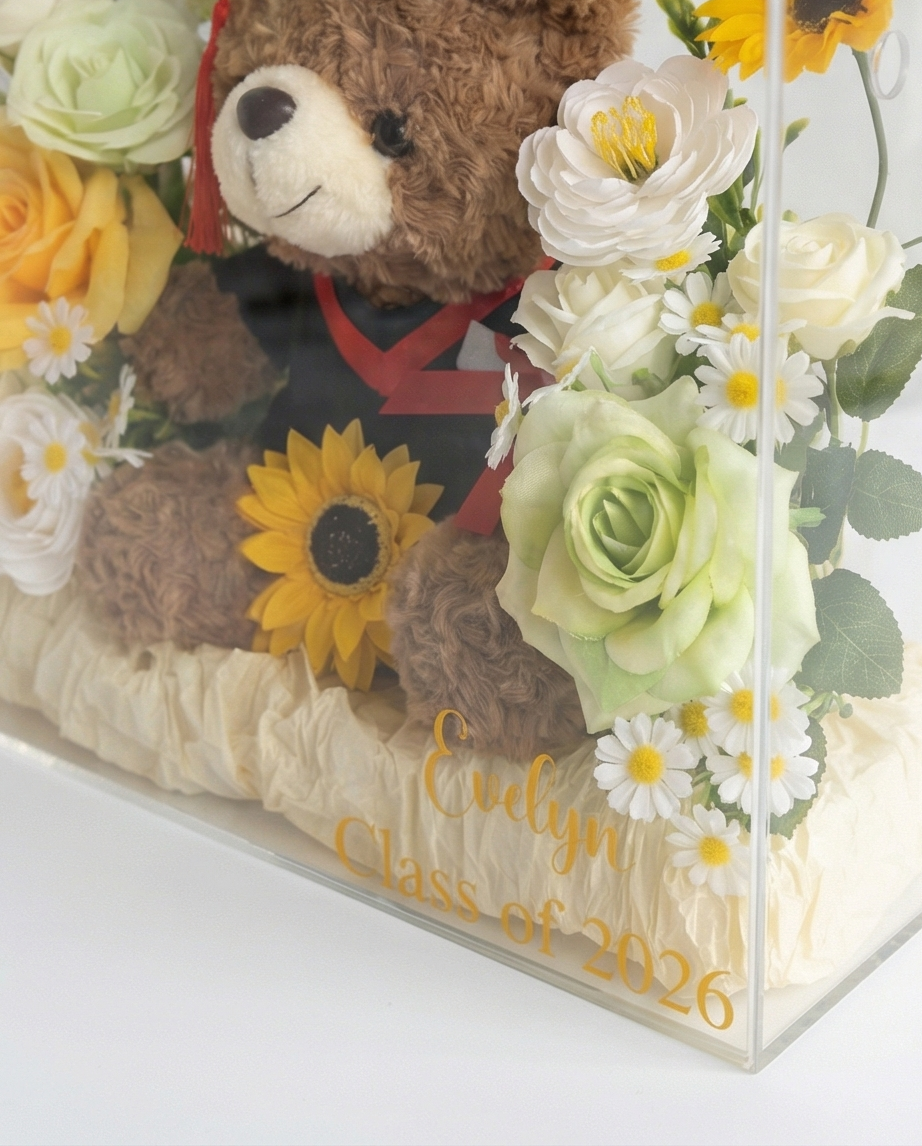 Graduation-themed teddy bear with flowers in a clear gift bag, flower close up
