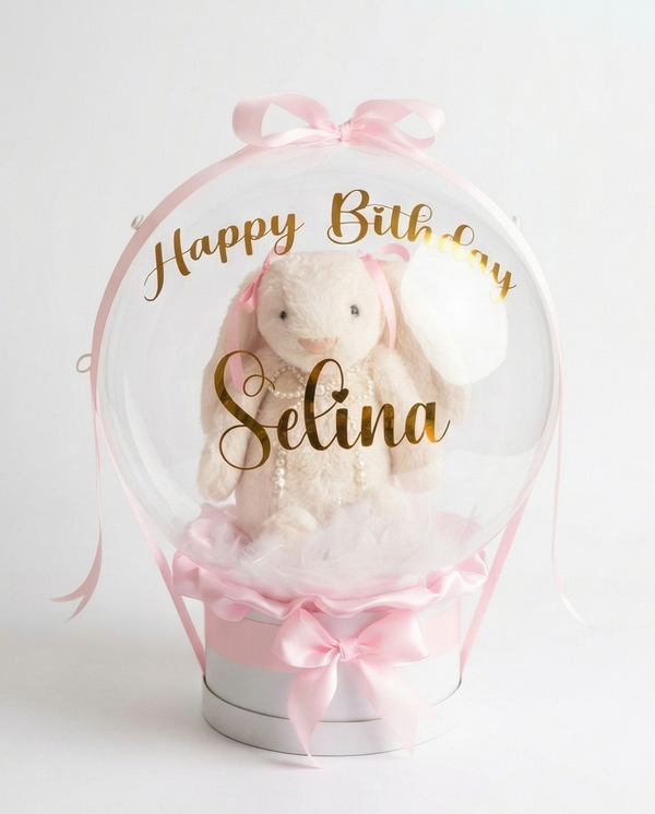 Teddy bear in a clear dome with pink ribbons, full view