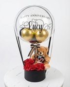 Decorative balloon with gold balloons, teddy bear, and red roses inside a clear dome, full product view