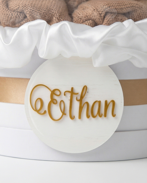 Baby shower gift with baby onesie, socks, and ultrasound photo inside a decorative box, name close up