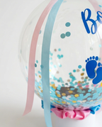 Black balloon with 'Boy' and 'Girl' text and footprints, ribbon close up