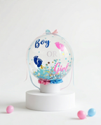 Baby shower decoration with 'Boy' or 'Girl' text and footprints in a transparent dome